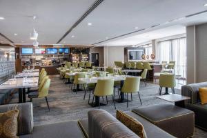 a restaurant with tables and chairs and a bar at Courtyard by Marriott Edmonton West in Edmonton