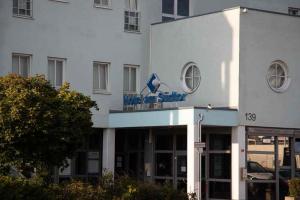 a white building with a sign on top of it at Hotel am Südtor in Backnang