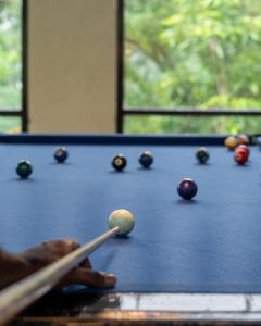 a person playing a game of pool on a table at Seed At Queens Meadows, Ranikhet in Rānīkhet +50 photos