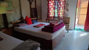 a bedroom with two beds with towels on them at Jyoti Home Bamboo Garden Lodge in Majuli