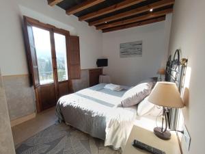 ロンダにあるHotel La PerlaBlancaのベッドルーム1室(ベッド1台、ランプ付きデスク付)