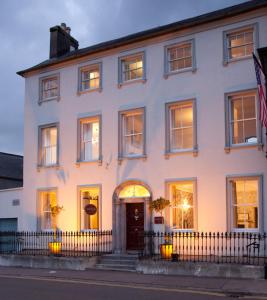 a white building with a fence in front of it at Long Quay House in Kinsale