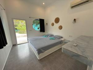a bedroom with a bed and a window at Los Penguin in Phumĭ Chroŭy Svay