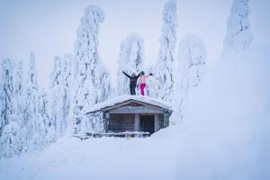 two people standing on top of a building covered in snow at Break Sokos Hotel Tahko in Tahkovuori