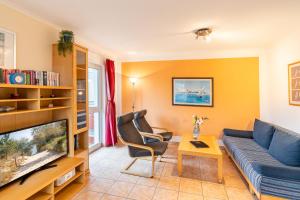 a living room with a couch and a tv at Düneneck 09 in Zempin