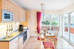 a kitchen with a table and a dining room at Düneneck 09 in Zempin +7 photos