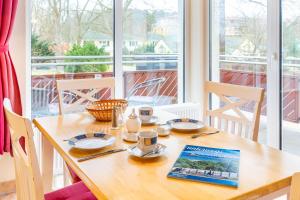 a table with two cups and a book on it at Düneneck 09 in Zempin