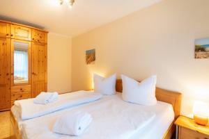 a bedroom with two beds with white pillows at Düneneck 09 in Zempin