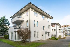 ツィノヴィッツにあるDünenresidenz 22の前に木がある白い建物