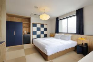 a bedroom with a large bed and a large window at evo Hotel Hakuba in Hakuba +5 photos