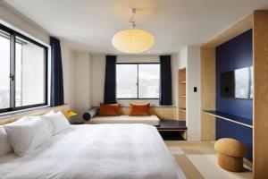 a bedroom with a large white bed and a couch at evo Hotel Hakuba in Hakuba