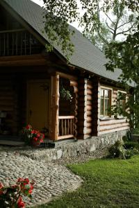Cabaña de madera con porche y puerta en Brīvdienu māja Pie sievasmātes en Cesvaine