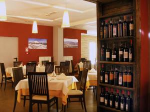 - une salle à manger avec des tables et des bouteilles de vin dans l'établissement Hotel Dolomiti Chalet, à Vason