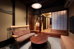 una sala de estar con un sofá y una mesa en Rinn Rokujo Machiya, en Kioto