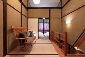 pasillo con silla y cama en una habitación en Rinn Rokujo Machiya, en Kioto