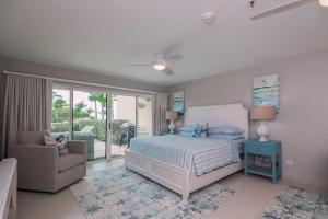 a bedroom with a bed and a couch and a window at Beachfront - Garden Delight 3BR condo - E125 in Palm-Eagle Beach +50 photos