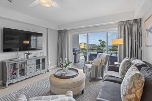 Una sala de estar con un sofá y un televisor en Beachfront - Summer View 2BR condo - A244, en Palm-Eagle Beach