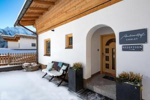 a patio with two chairs and a sign on a building at Chalet Andreashof in Gerlos