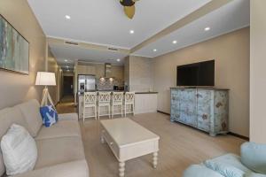 a living room with a white couch and a tv at Eagle Beach - Garden Breeze 1BR condo - LV101 in Palm-Eagle Beach