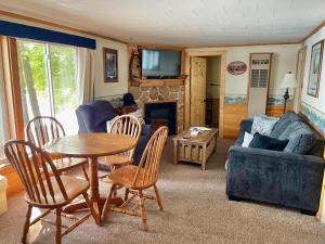 una sala de estar con una mesa, sillas y un sofá en Pine Haven Unit #3, en Saint Germain