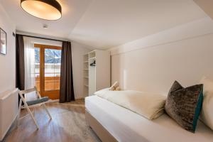 a bedroom with a white bed and a window at Chalet Andreashof in Gerlos