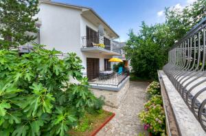 a balcony of a house with a bench and a garden at OMERCIC in Jadranovo