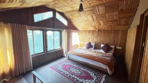 a bedroom with a bed in a room with windows at PineNest Cottages & Cafe in Jibhi