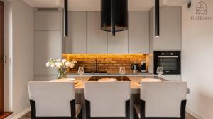 a kitchen with a table with chairs and wine glasses at City Center SPA Apartments Jaglana 6E,F in Gdańsk +49 photos