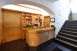 a woman standing at a counter in a building at Hotel Am Reschensee in Resia