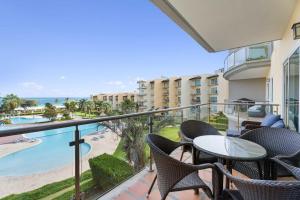 Un balcón con mesas y sillas y vistas al océano. en Beachfront - Amazing View 2BR condo - A342, en Palm-Eagle Beach