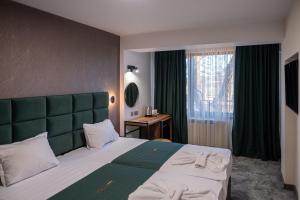 Un dormitorio con una cama grande y una ventana. en Complex Ekaterina, en Yambol