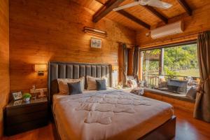 a bedroom with a large bed in a room with wooden walls at SaffronStays Timber Crest in Dehradun
