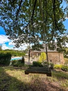 a swing hanging from a tree near a pool at Gîte le relais de la diligence in Le Lardin-Saint-Lazare +37 photos