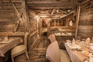 restauracja z drewnianymi ścianami, stołami i krzesłami w obiekcie Sporthotel Romantic Plaza w Madonna di Campiglio