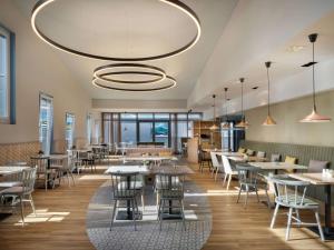 a restaurant with tables and chairs and a large chandelier at Hilton Garden Inn Innsbruck Tivoli in Innsbruck