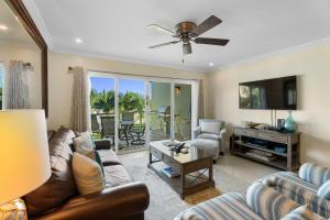 Una sala de estar con un sofá y un televisor. en Beachfront - Absolute Luxury 2BR condo - BC254, en Palm-Eagle Beach