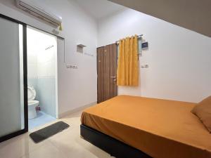 a bedroom with a bed and a bathroom with a toilet at Sejahtra Rawamangun in Jakarta
