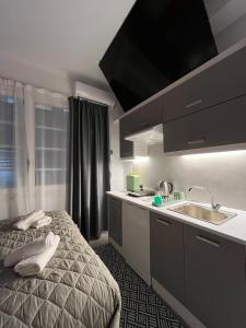 une petite cuisine avec un lit et un évier dans l'établissement Medusa suite stadiou by Zeussuites, à Athènes