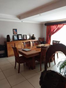 a dining room with a wooden table and chairs at Mbele's home stay in Bloemfontein
