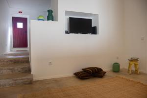 a living room with a flat screen tv on a wall at Casa da Xica - Casinhas com Alma in Torrão