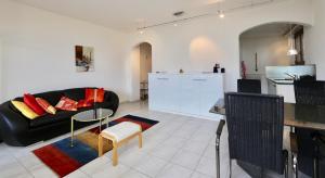 a living room with a black couch and a kitchen at Ferienwohnung C05 in Orselina