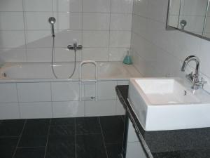 La salle de bains est pourvue d'un lavabo et d'une baignoire. dans l'établissement FeWo am Mu-Cafe, à Emmerich