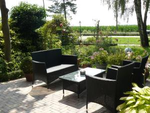eine Terrasse mit Stühlen und einem Tisch im Garten in der Unterkunft FeWo am Mu-Cafe in Emmerich