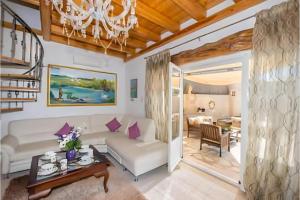 a living room with a white couch and a chandelier at Siorra Angelina Villa in Perítheia