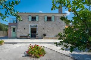 a large stone house with a courtyard in front of it at Siorra Angelina Villa in Perítheia