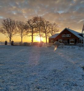 a barn in a field with the sunset in the background at De Mast bij Fort Vechten on the countryside & close to Utrecht in Bunnik