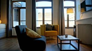 een woonkamer met 2 stoelen en een tafel bij Little Suite - Héloise in Lille