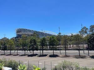 悉尼Modern 3B2B apt with superb stadium view at sydney olympic park的停车场里有很多树木的体育场