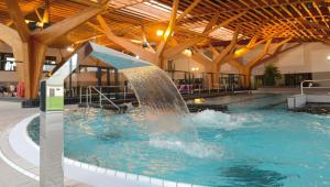 a fountain in a swimming pool in a building at La dépendance in Maisse