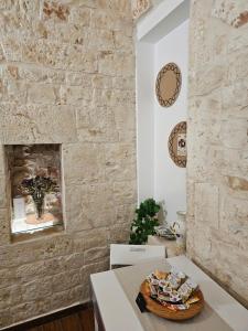 a room with a table and a stone wall at PietraRosa Apartment in Triggianello